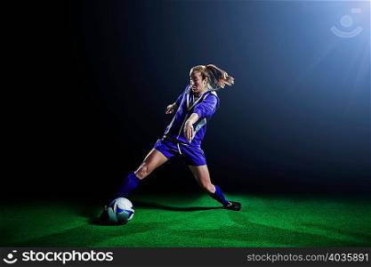 Young female soccer player dribbling ball