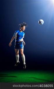 Young female soccer player heading ball