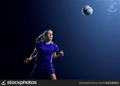 Young female soccer player heading ball