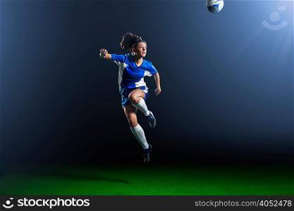 Young female soccer player mid air