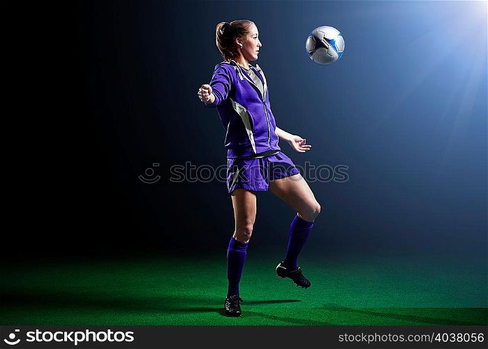 Young female soccer player with ball