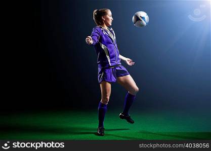 Young female soccer player with ball