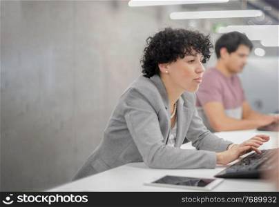 young female software developer using desktop computer while writing programming code at modern creative startup office