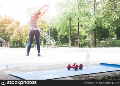 Young female stretching before exercising at the park, Healthy lifestyle concept