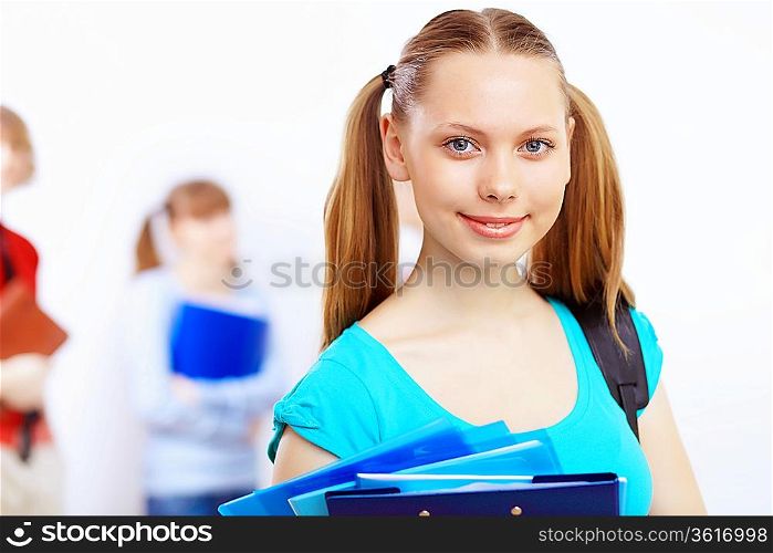 Young female student at college with books