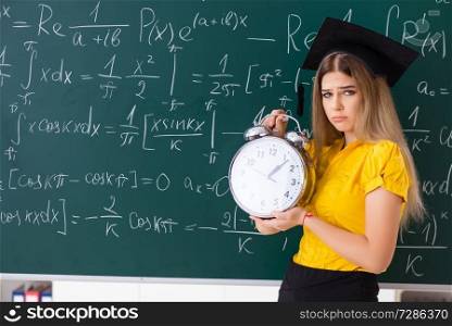 Young female student in front of the chalkboard  