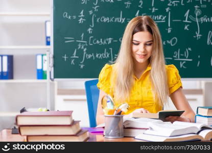 Young female student in front of the chalkboard  