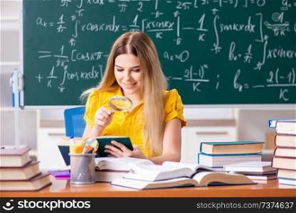 Young female student in front of the chalkboard  