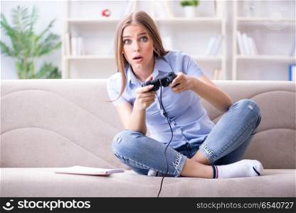 Young female student playing games at home