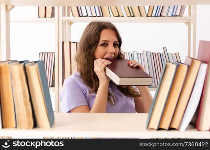 Young female student preparing for exams at library 