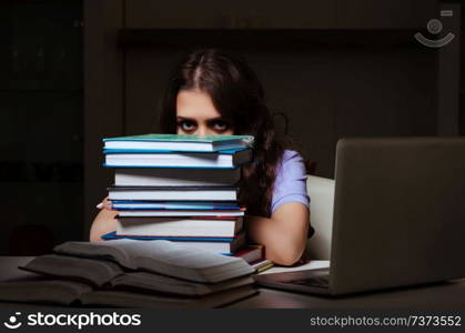 Young female student preparing for exams late at home 