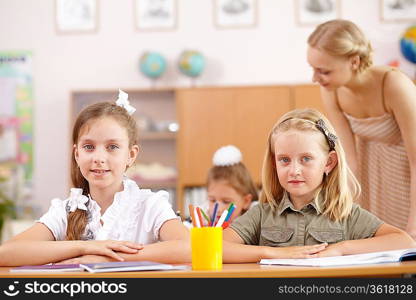 Young female teacher working with children at school