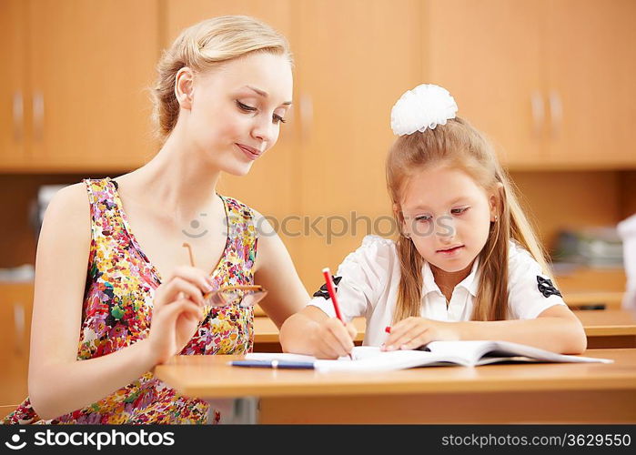 Young female teacher working with children at school