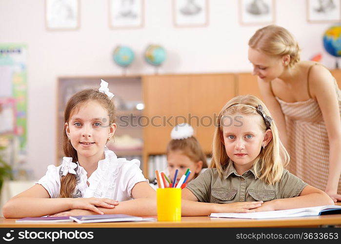 Young female teacher working with children at school