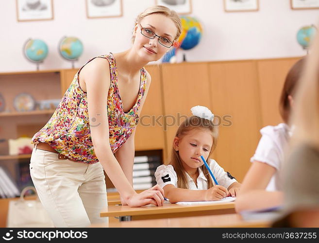 Young female teacher working with children at school