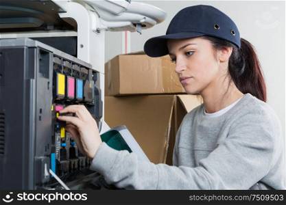 young female technician fixing a printer