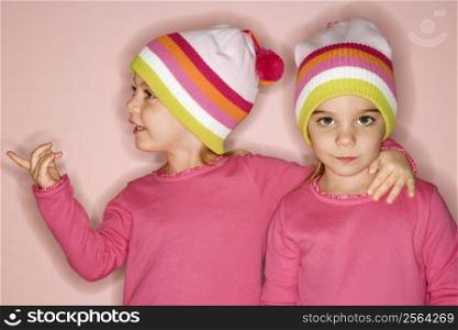 Young female twin Caucasian children standing together.