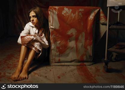 Young female victim of psychiatrist butcher in mental hospital basement. Frightened patient of doctor maniac in clinic for the mentally ill