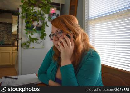 Young female with glasses on android cell phone in a home setting