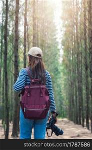 Young female woman lifestyle photographer travel taking photo in forest nature with backpack and copy space.