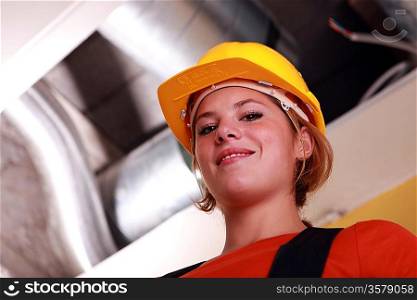 Young female worker by exposed ventilation
