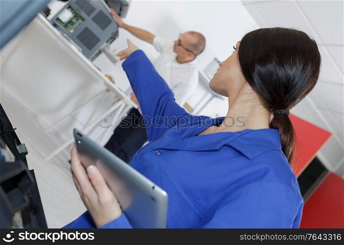 young female worker using digital tablet in manufacturing industry