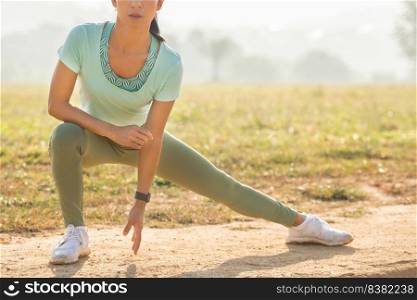 young female workout before fitness training session at the park. woman stretching for warming up before running or working out. fitness and healthy lifestyle concept.