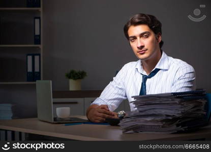 Young financial manager working late at night in office . The young financial manager working late at night in office 