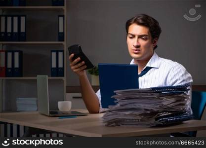 Young financial manager working late at night in office 