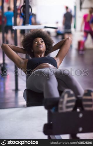 young fit african american woman doing sit ups in fitness studio at the gym.Abdominal exercises Sit up