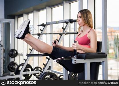 Young fit woman at the gym doing abs workout, healthy lifestyle and fitness concept