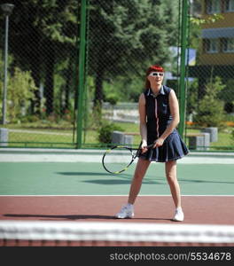 young fit woman play tennis outdoor on orange tennis field at early morning