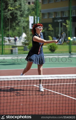 young fit woman play tennis outdoor on orange tennis field at early morning