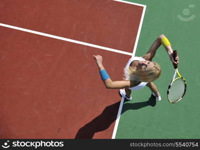 young fit woman play tennis outdoor on orange tennis field at early morning