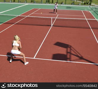 young fit woman play tennis outdoor on orange tennis field at early morning