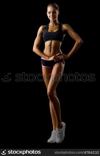 Young fitness girl isolated on black