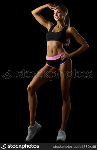 Young fitness girl isolated on black