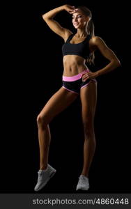 Young fitness girl isolated on black