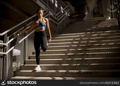 Young fitness woman doing exercises outdoor in urban enviroment