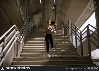 Young fitness woman doing exercises outdoor in urban enviroment