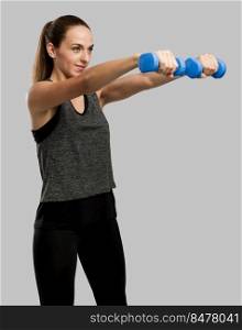 Young fitness woman making exercises with dumbbells