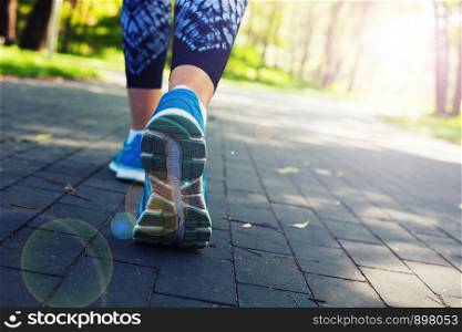 young fitness woman runner athlete legs running at city park road