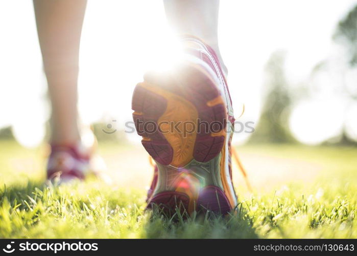 Young fitness woman running, Training and healthy lifestyle. Runner feet running on road closeup on shoe