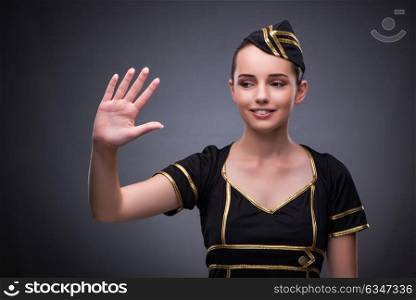 Young flight attendant on gray background