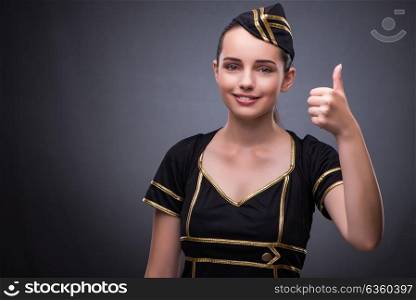 Young flight attendant on gray background