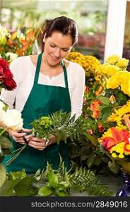 Young florist preparing flowers bouquet shop store smiling colorful