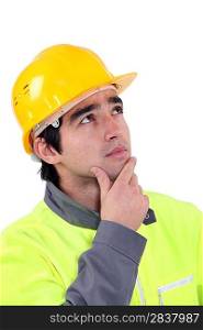 young foreman looking upwards against white background