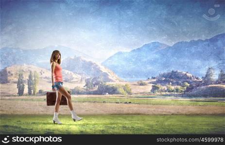 Young free hitchhiker. Traveler woman walking with retro suitcase in hand