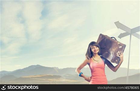 Young free hitchhiker. Traveler woman walking with retro suitcase on shoulder