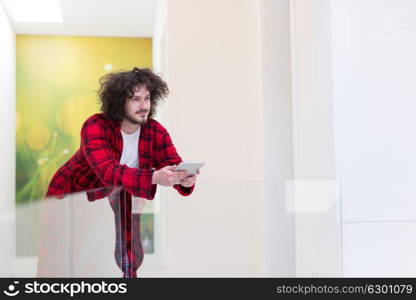 young freelancer in bathrobe working from home using tablet computer